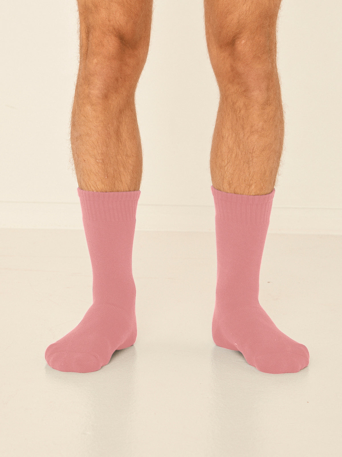Model wearing dusty pink mid rise thick work, hiking, bed socks with ribbed top and thick cushioned sole, bamboo socks