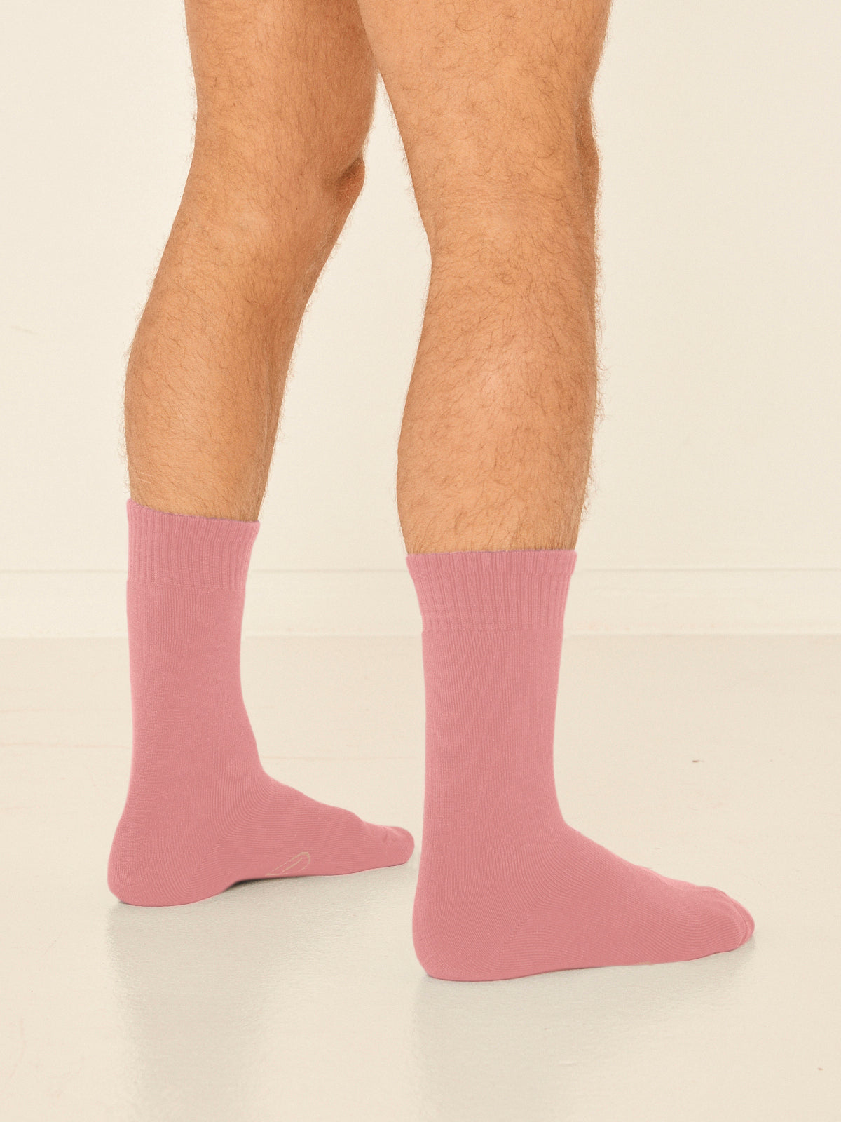 Model wearing dusty pink mid rise thick work, hiking, bed socks with ribbed top and thick cushioned sole, bamboo socks