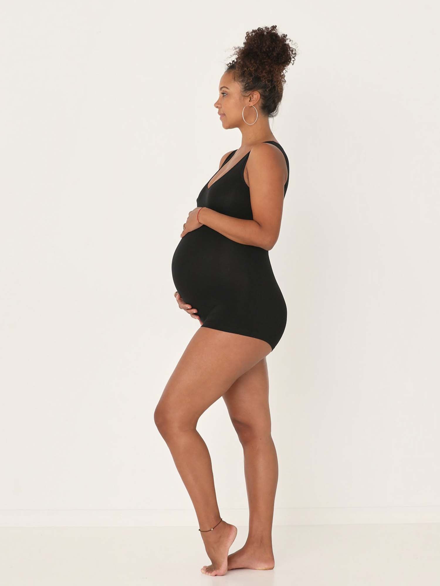 Model wearing a reversible black boyleg bodysuit with scoop and boat necklines, women's bamboo clothing