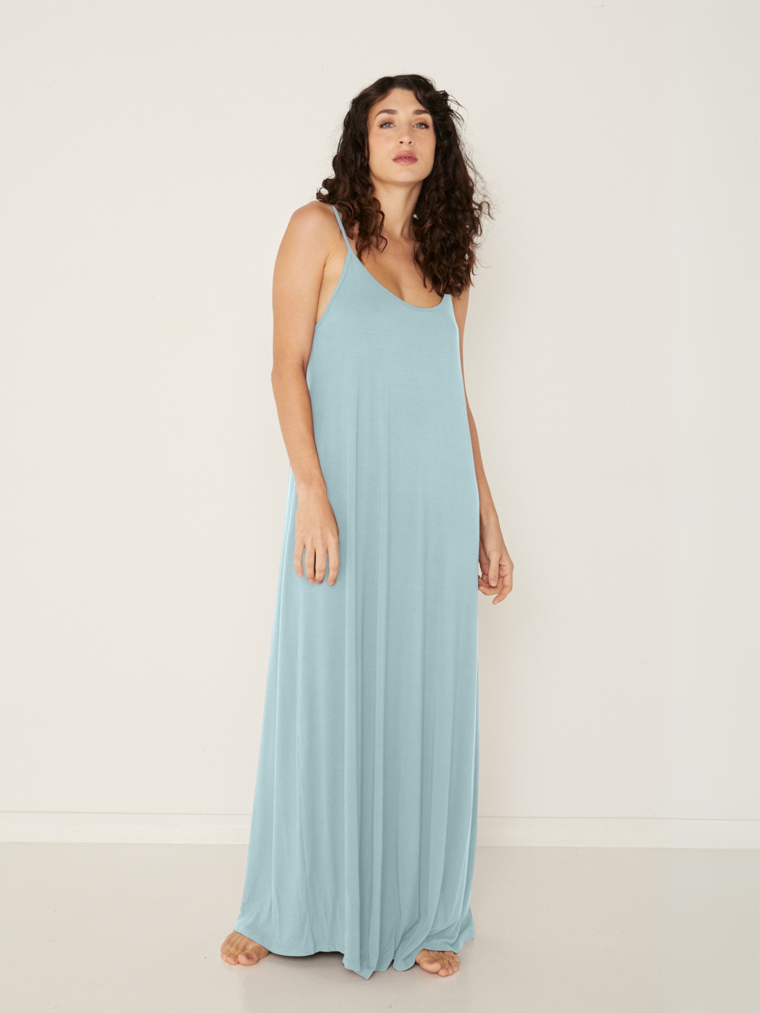 Woman wearing a light topaz blue bamboo maxi dress against a white background