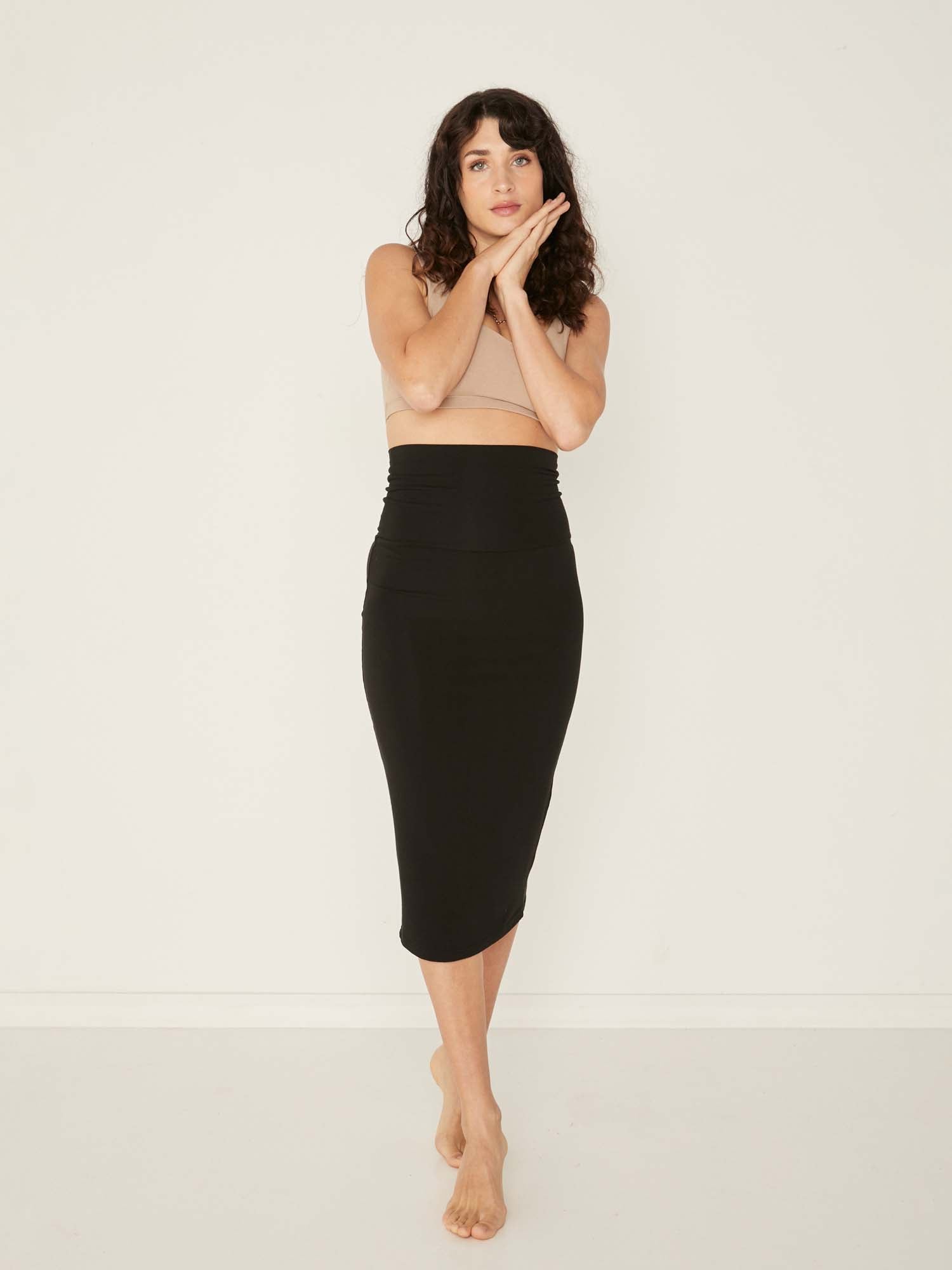 Model wearing black midi pencil tube skirt, mid calf length with a deep waistband, women's bamboo clothing