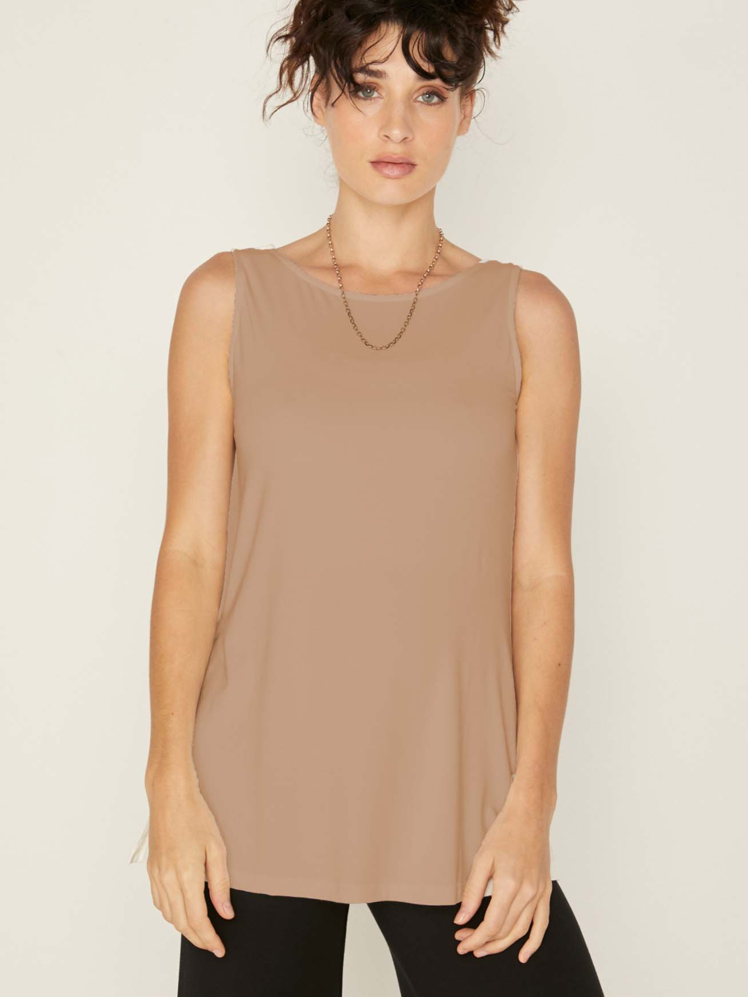 Model wearing a reversible caramel a-line singlet with scoop and boat necklines and long line body, women's bamboo clothing