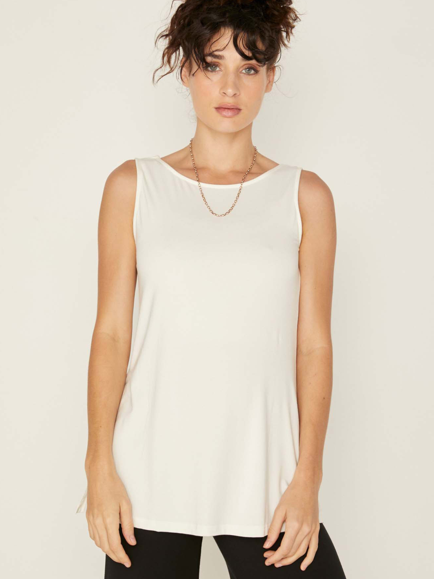 Model wearing a reversible cream a-line singlet with scoop and boat necklines and long line body, women's bamboo clothing