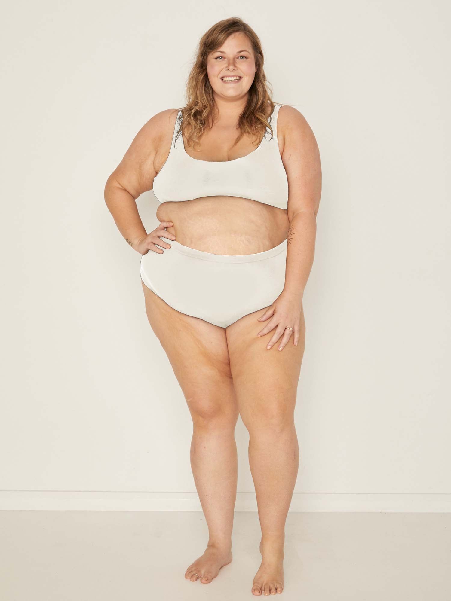 Model wearing cream high waisted full brief with mid leg opening and double layered waistband, women's bamboo underwear