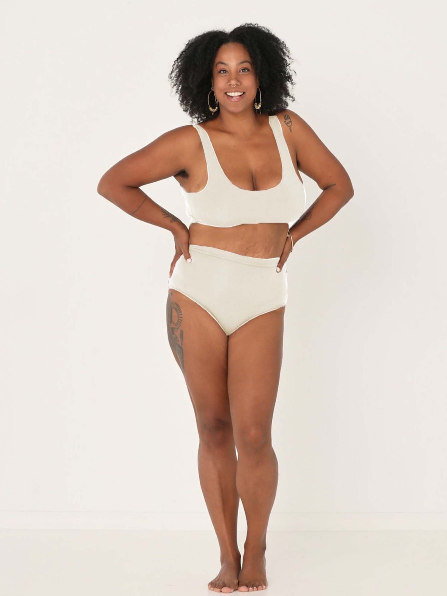 Model wearing cream high waisted full brief with mid leg opening and double layered waistband, women's bamboo underwear