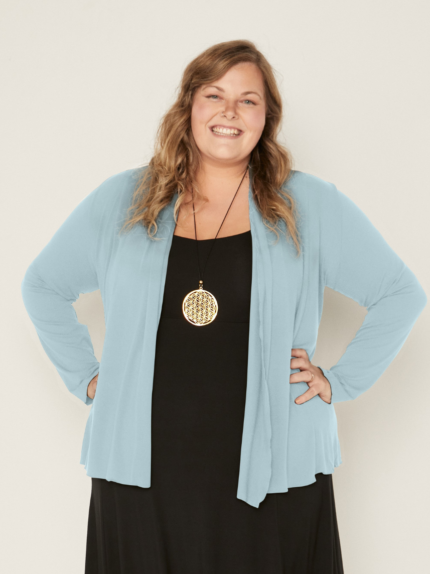 Woman wearing a bamboo topaz blue mid cardigan over a black dress against a white background