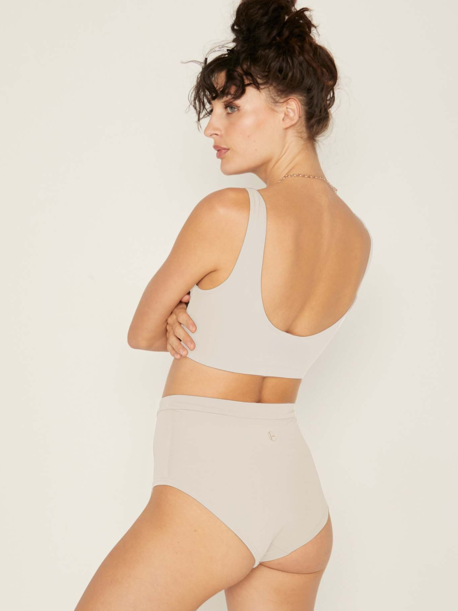 Model wearing cream reversible bra, high or low scoop neckline and wide shoulder straps, wireless bra, women's bamboo underwear