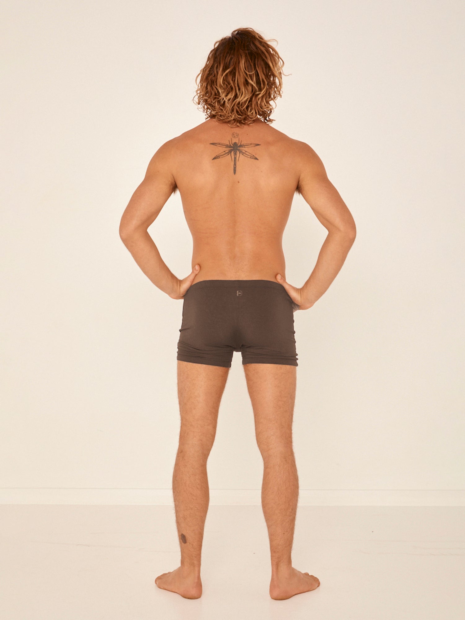 Male model wearing cocoa trunk style boxer shorts with a soft elasticated waistband and pouch detail stiching, men's bamboo underwear