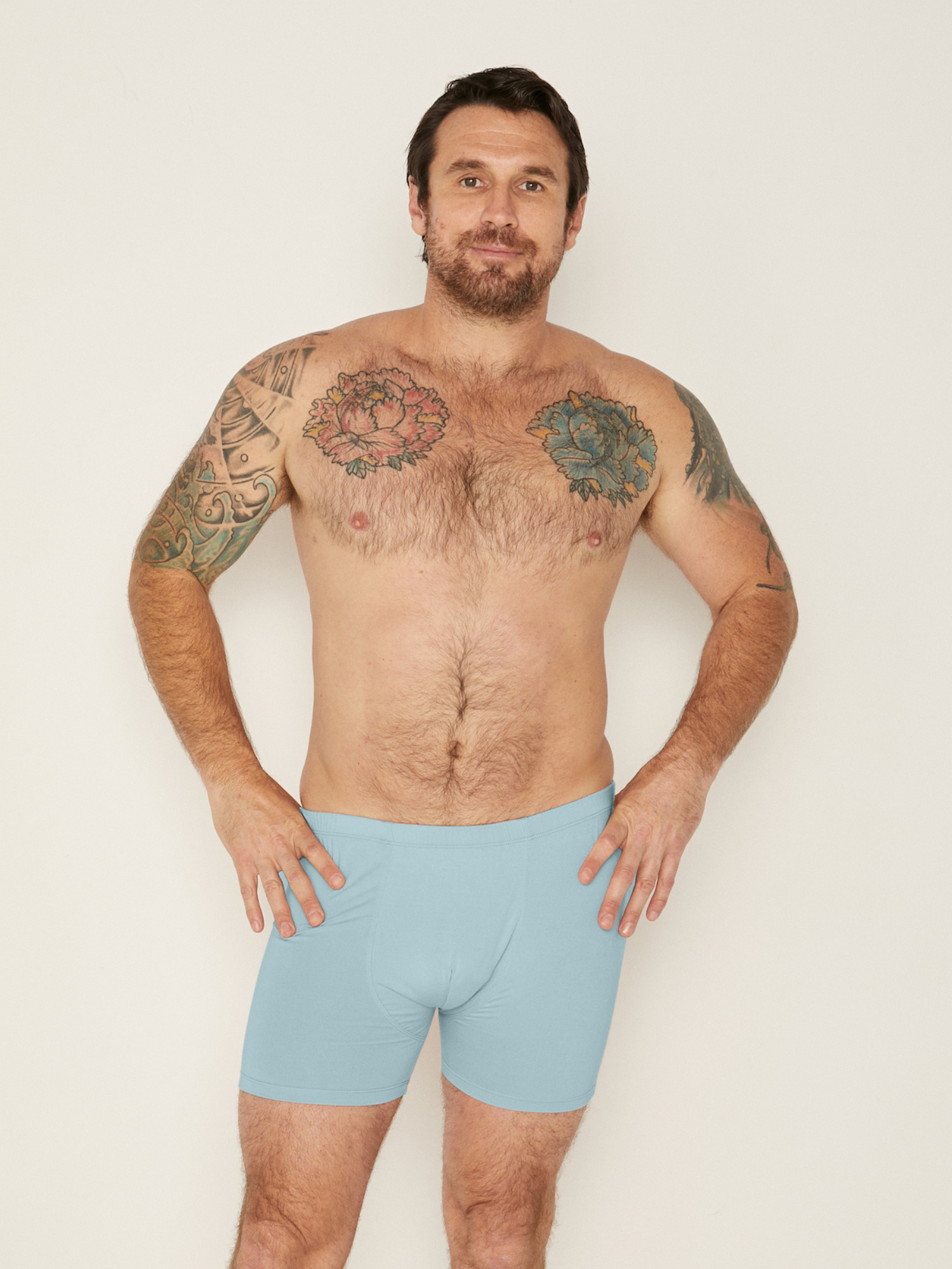 model wears light topaz blue men's boxer briefs on a white background