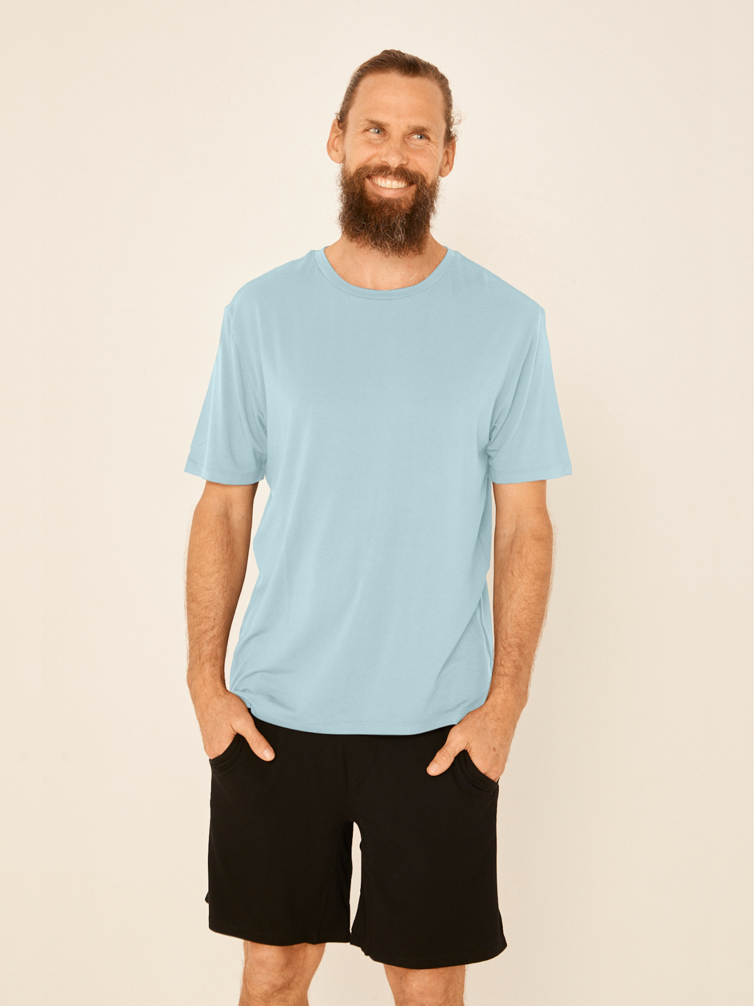 Male model wearing light topaz blue generous classic fit tee, soft neckband, crew neckline, short sleeve, men's bamboo clothing