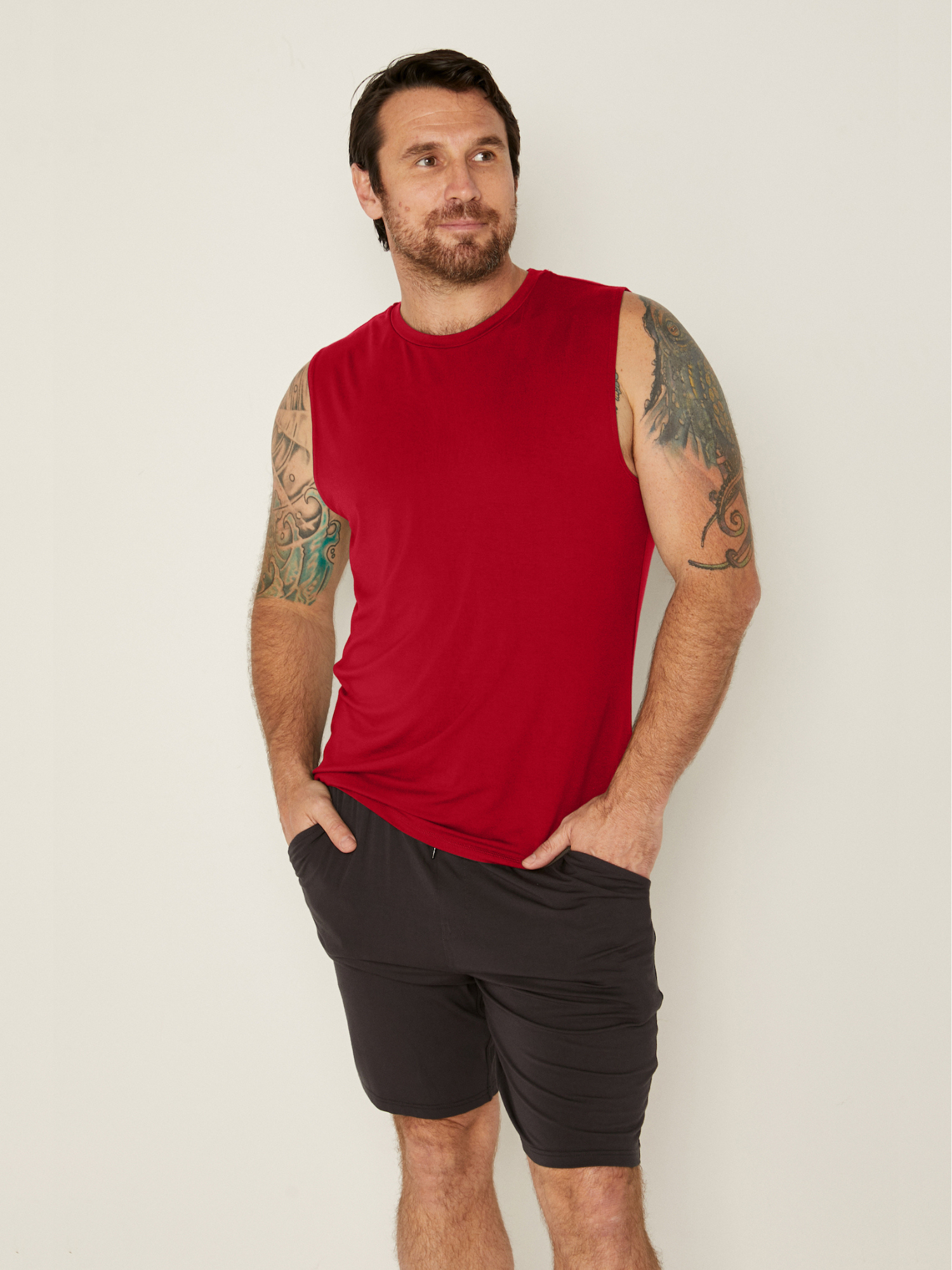 male model wearing chili red generous classic fit tank singlet, soft neckband, crew neckline, sleeveless, men's bamboo clothing