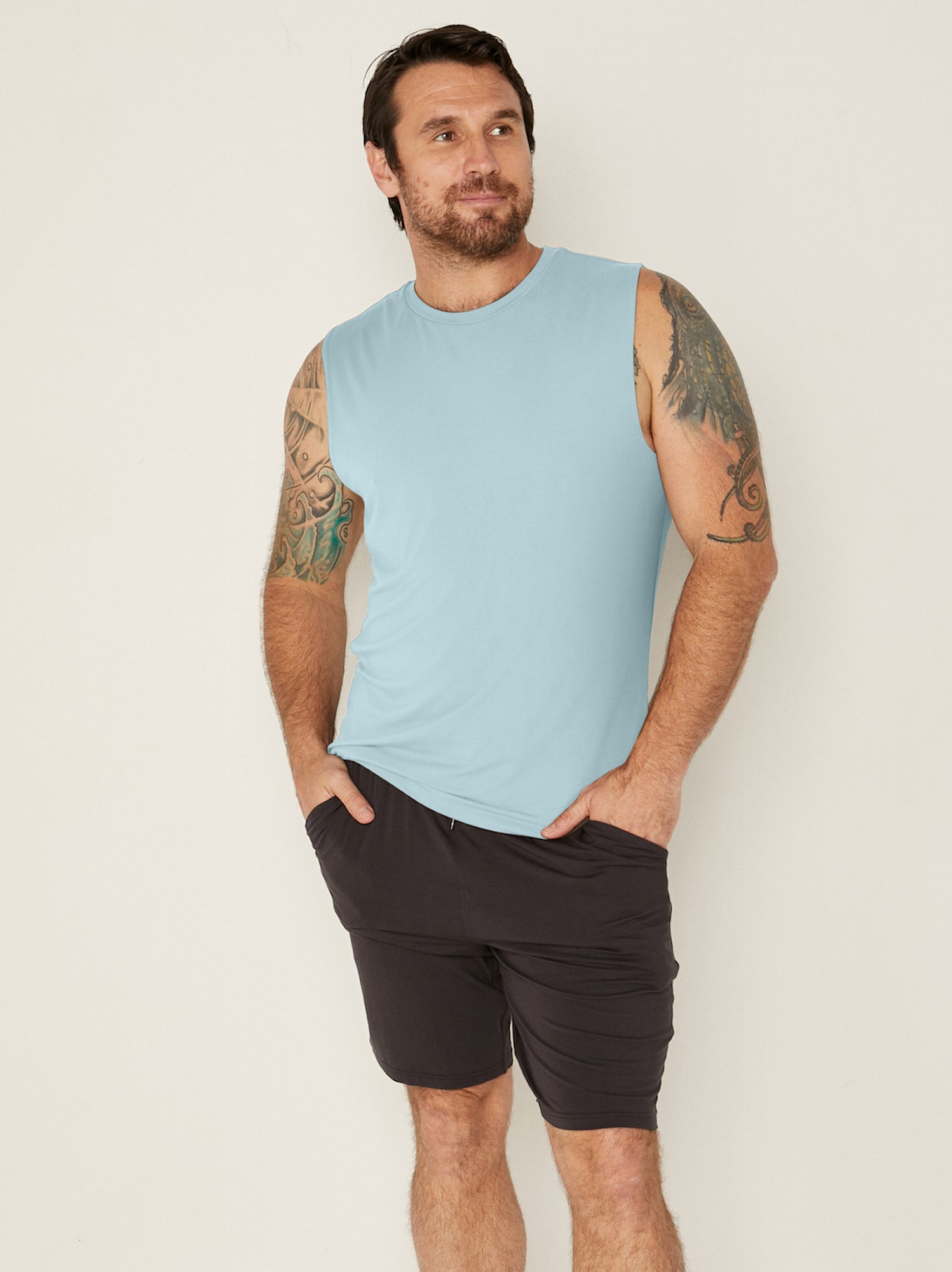 male model wearing light topaz blue generous classic fit tank singlet, soft neckband, crew neckline, sleeveless, men's bamboo clothing