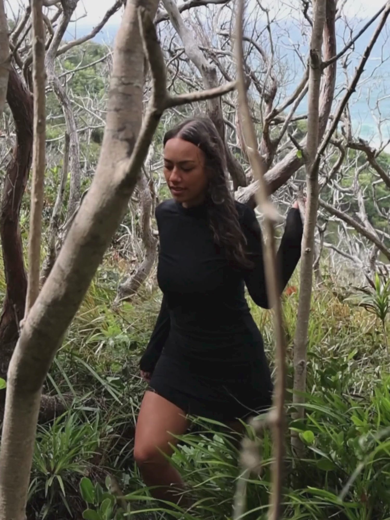 video of a girl walking in a forest wearing a black skivvy and skirt